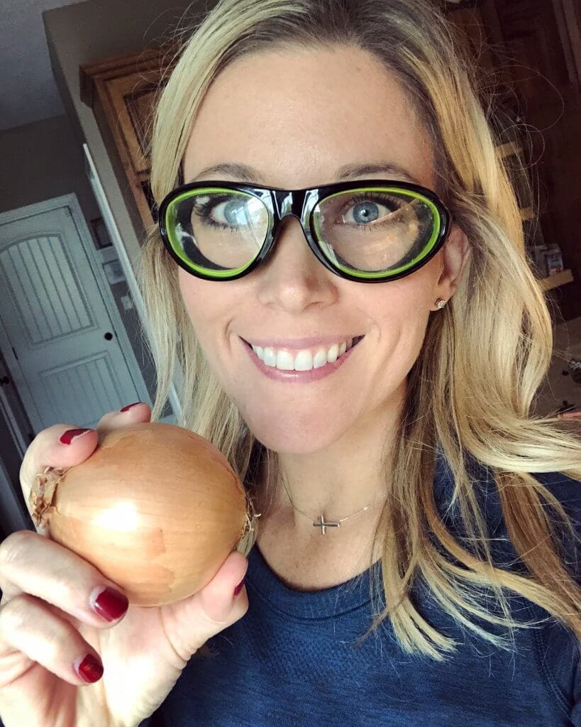 Amy holding an onion and wearing onion goggles