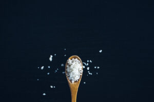 black background with a spoon full of salt