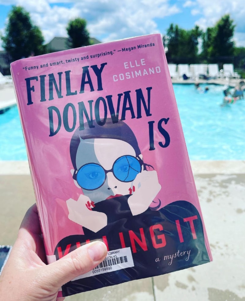 the book finlay donovan is killing it being held in front of a pool