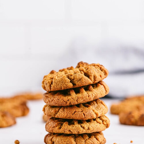 peanut butter cookies stacked on top of one another with a white background